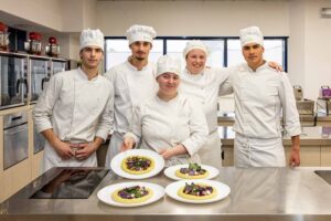 La squadra di cucina vincitrice del concorso "La Salute nel Piatto 2026" presenta il piatto premiato, la pizza “Astro d’inverno”.