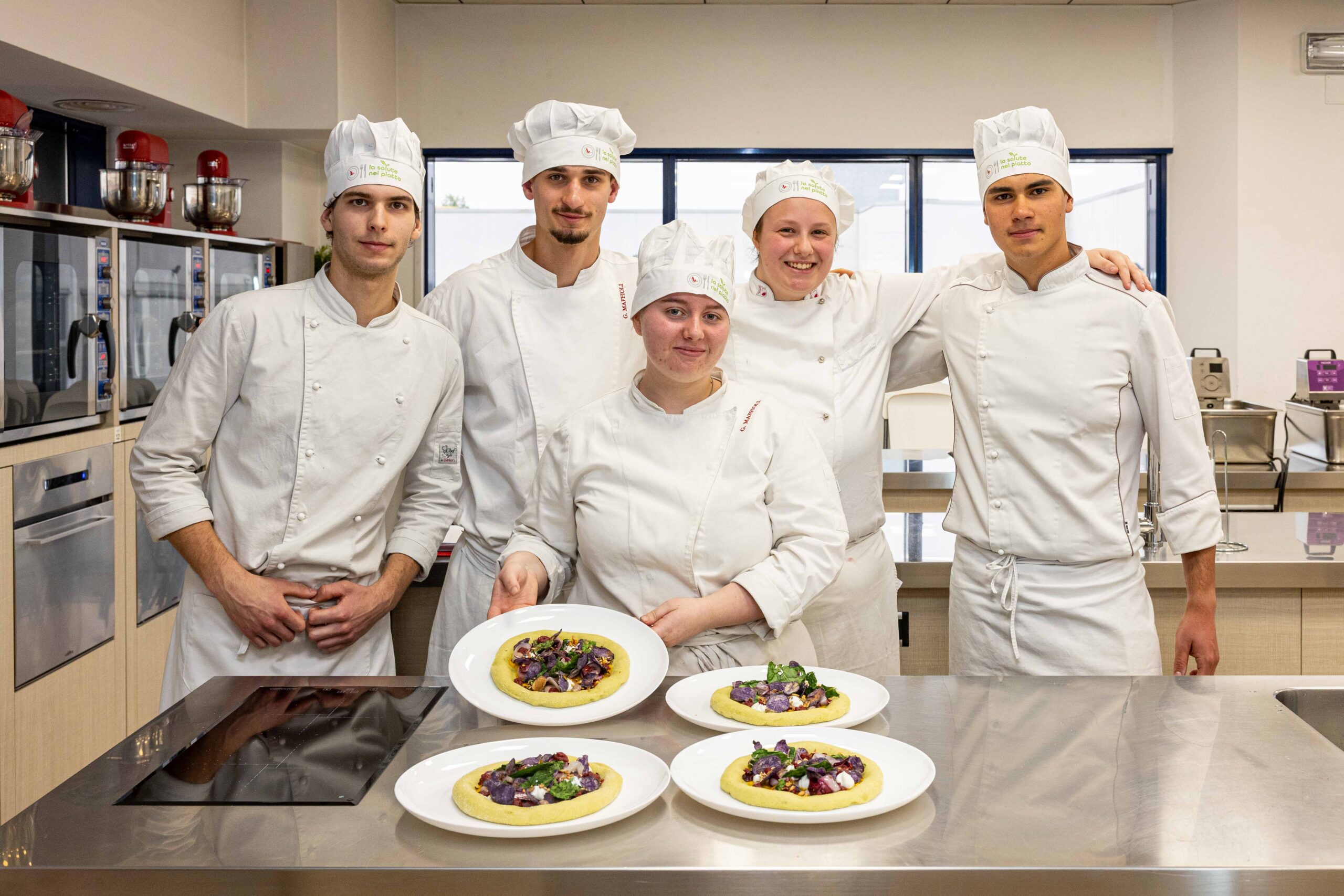 La squadra di cucina vincitrice del concorso "La Salute nel Piatto 2026" presenta il piatto premiato, la pizza “Astro d’inverno”.
